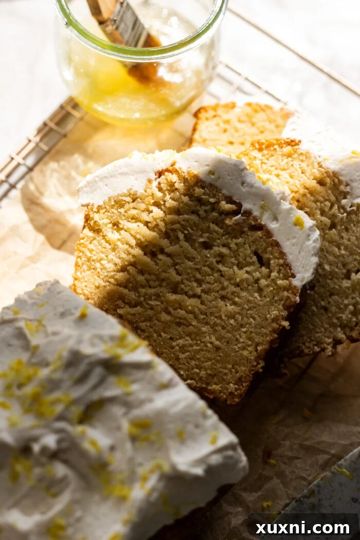 Perfectly sliced vegan lemon loaf cake, showcasing its moist texture and golden crust.