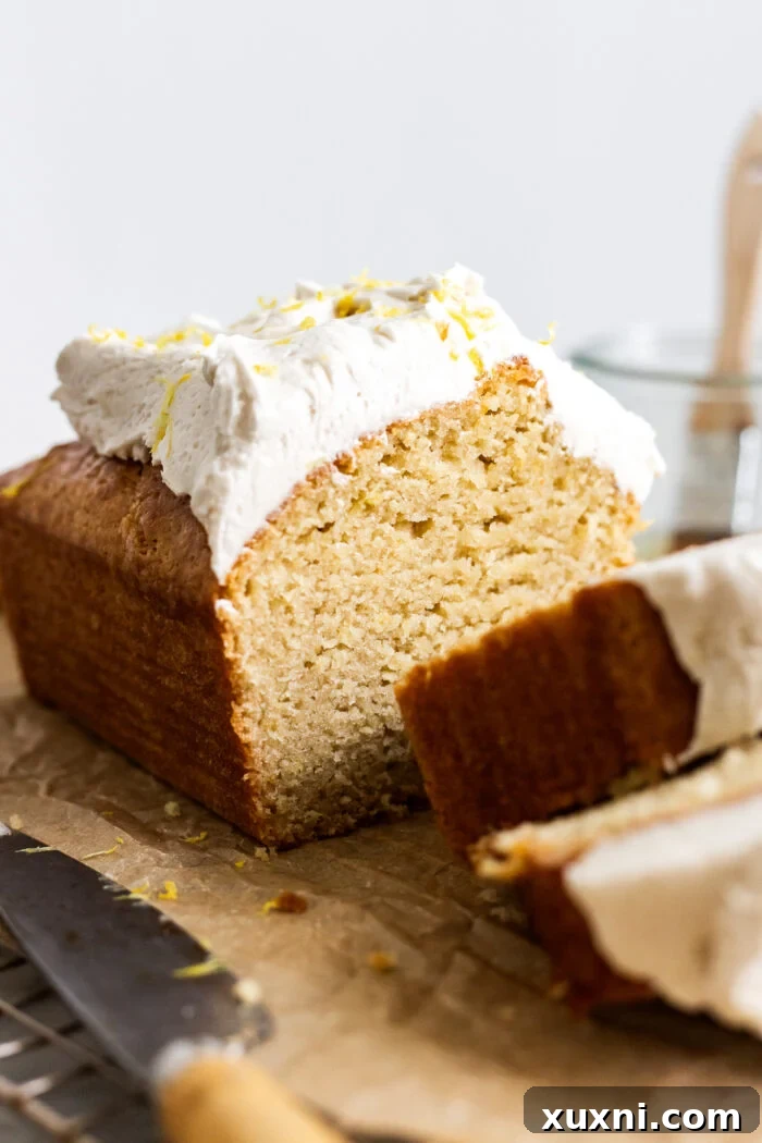 Sliced vegan lemon loaf cake on a cooling rack, showing the beautiful crumb texture.