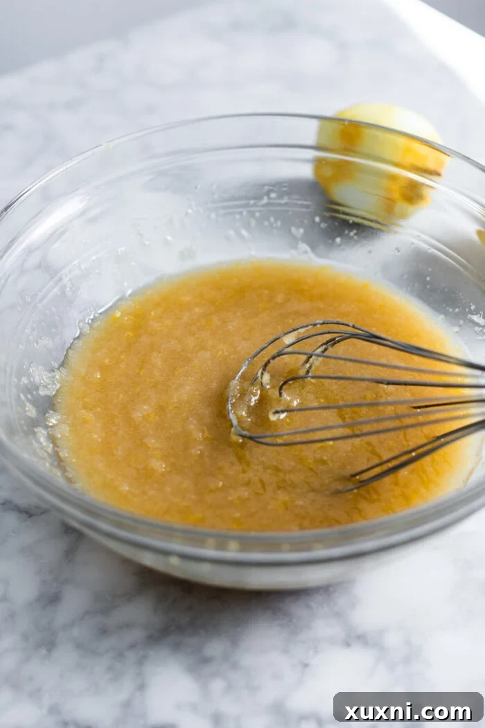 Wet ingredients being whisked together in a bowl for the lemon drizzle cake.