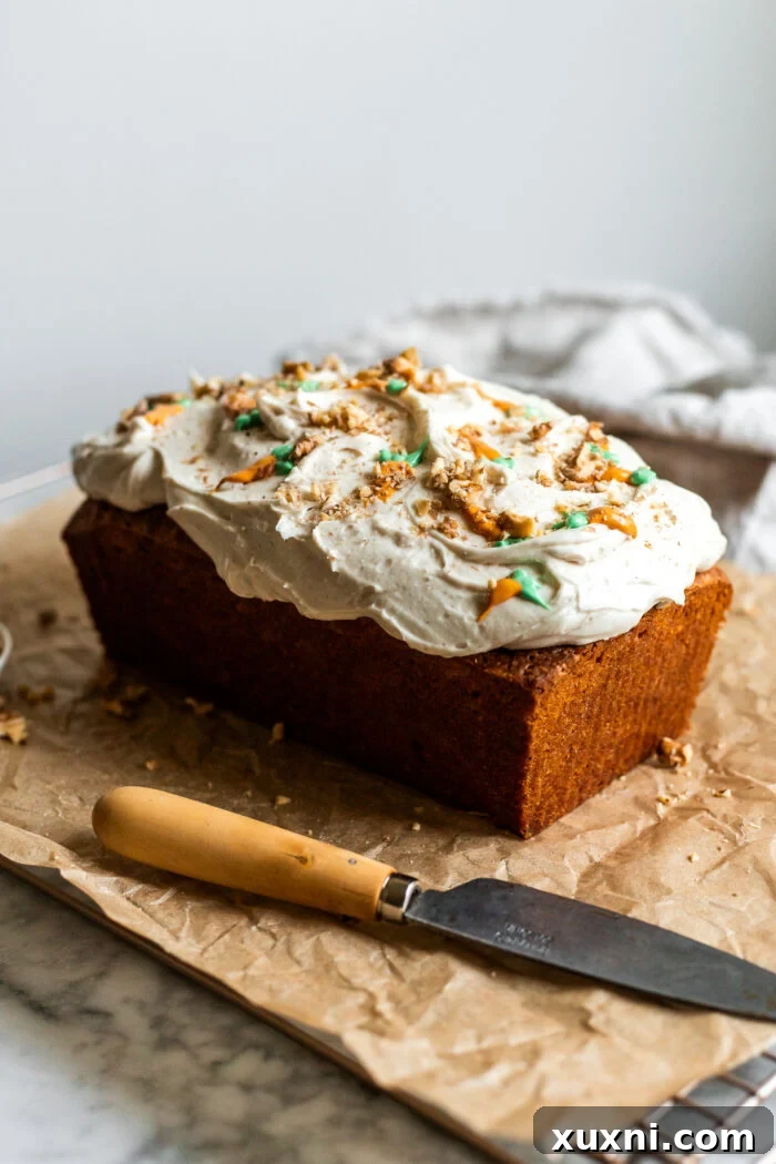Fully frosted vegan carrot cake loaf, ready to be served.