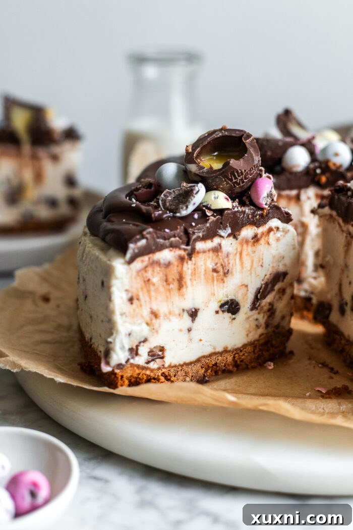 Sliced vegan Easter egg cheesecake revealing a creamy filling and cookie crust with colorful candies