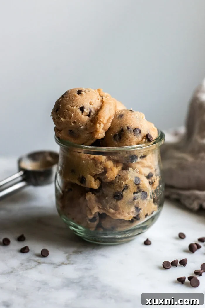 jar of cookie dough with scoop behind it