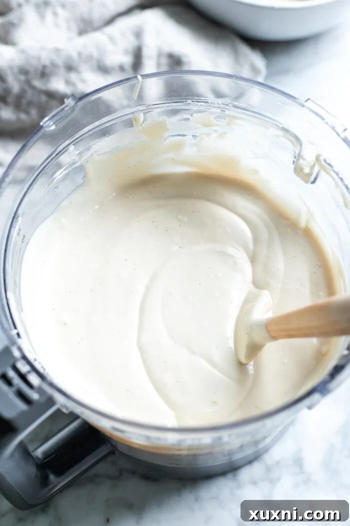 Creamy cheesecake batter being prepared in a food processor.