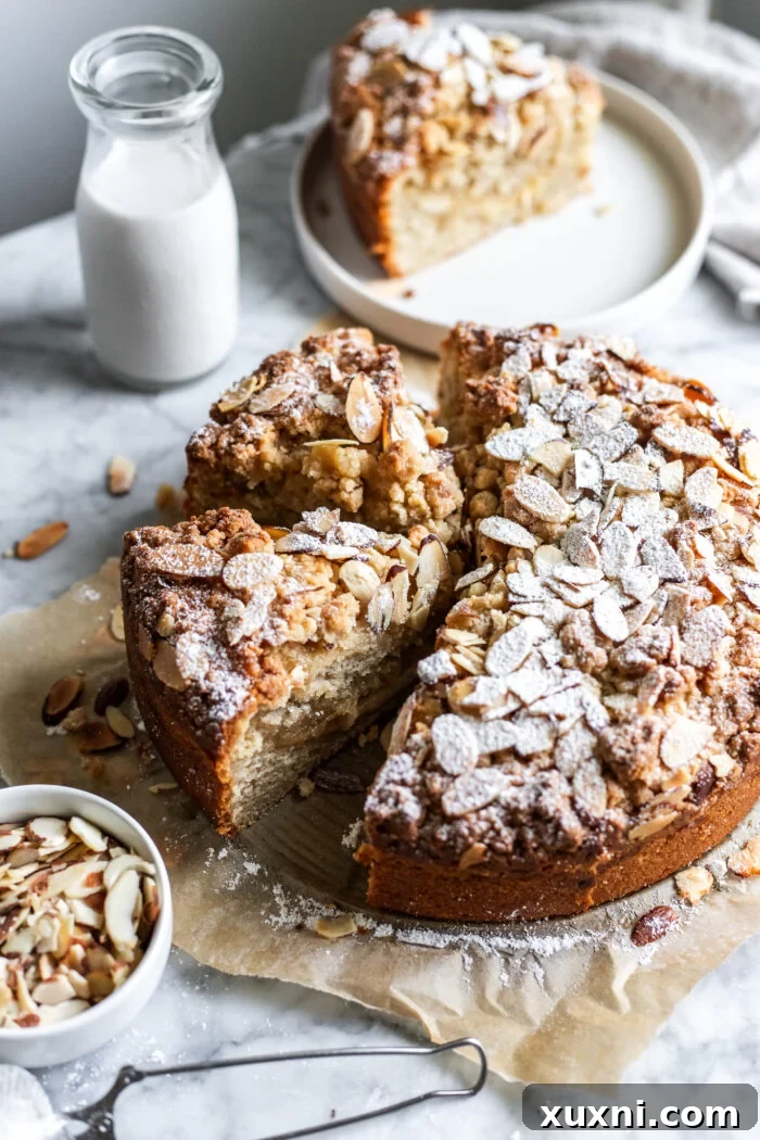 Close-up of a beautifully sliced vegan almond coffee cake on a marble table.