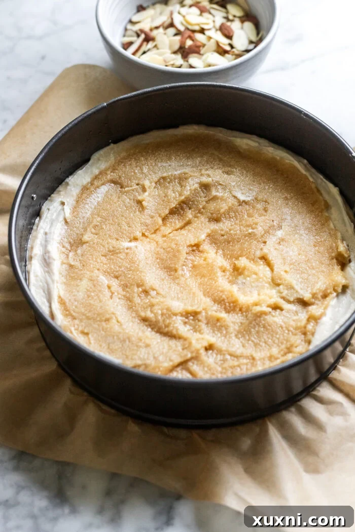 First layers of vegan almond coffee cake being assembled in a springform pan.