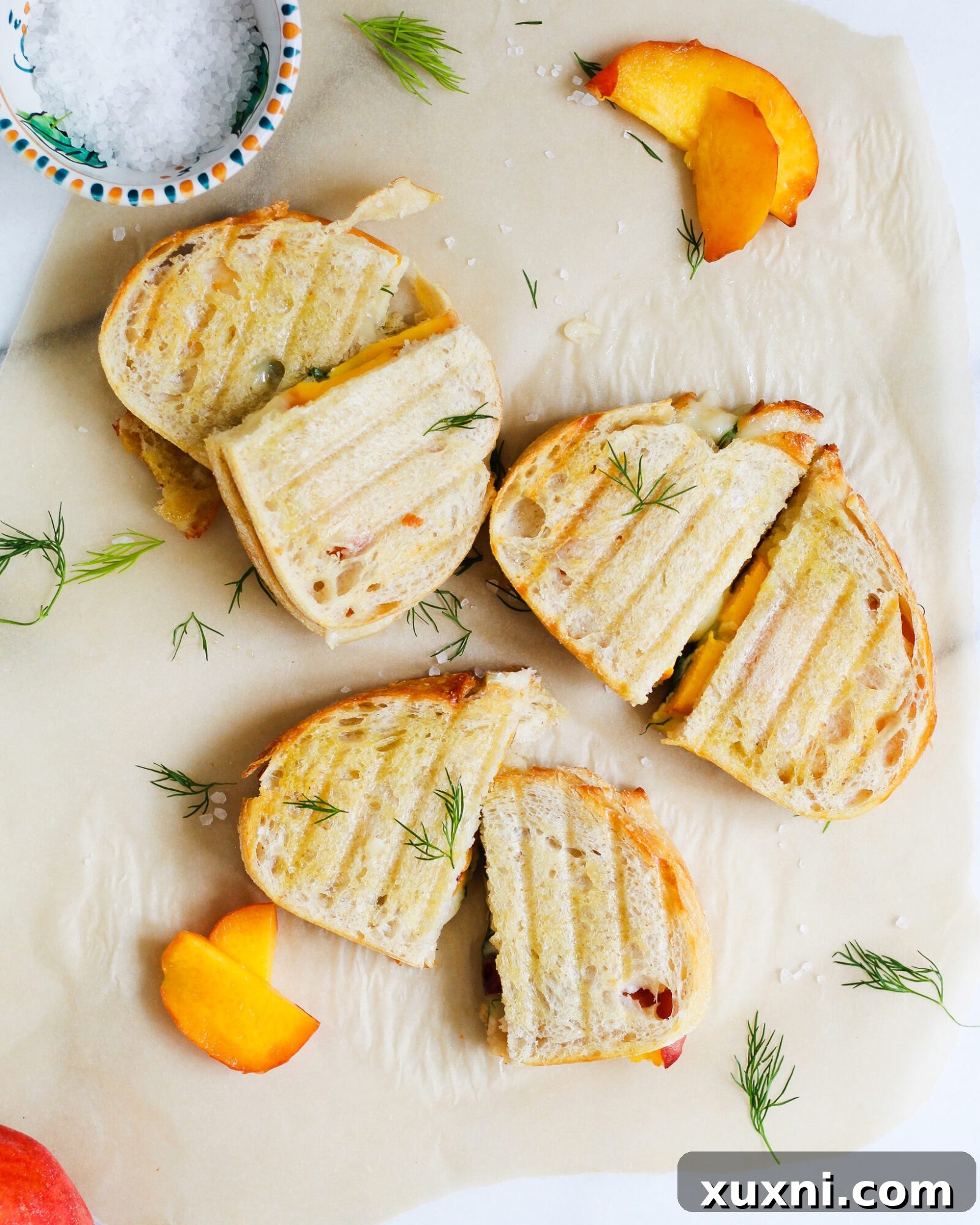 three peach grilled cheese sandwiches on parchment paper