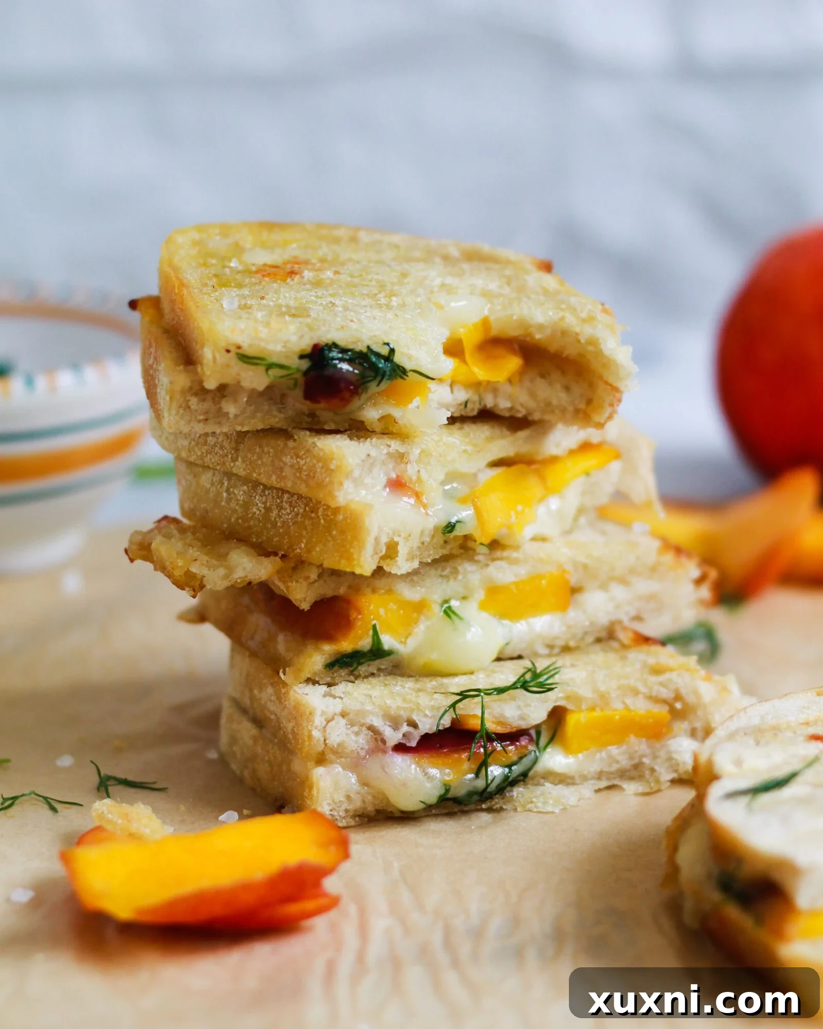 bite taken out of peach and brie grilled cheese sandwich stack