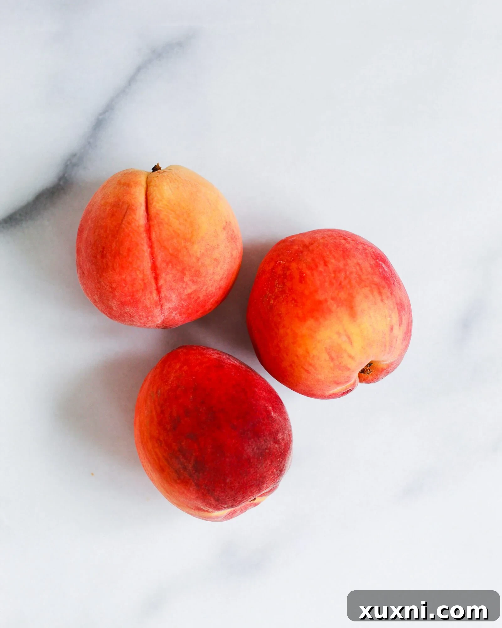 three peaches on marble slab