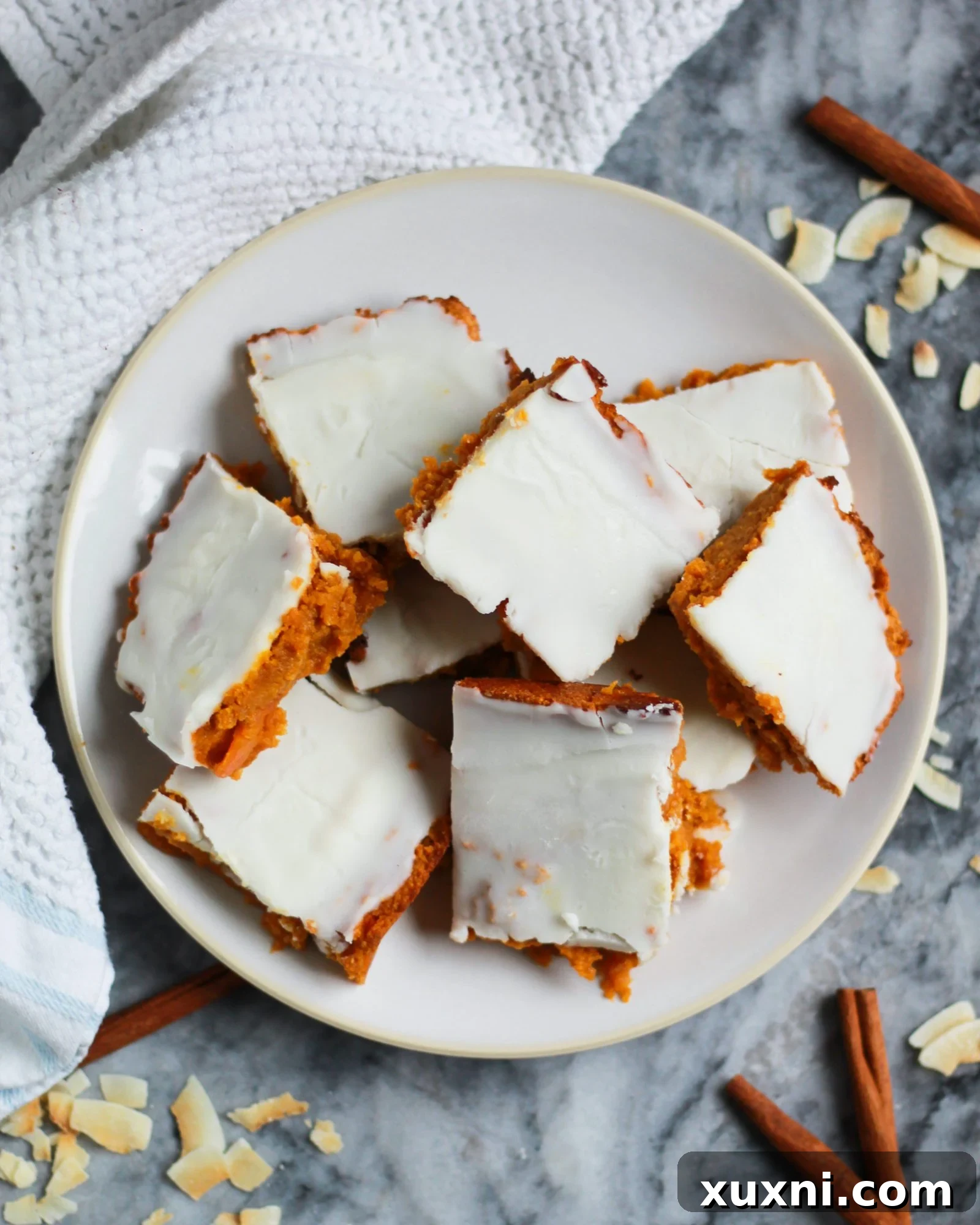 Plate of beautifully frosted paleo vegan carrot cake bars, showcasing their wholesome appeal.
