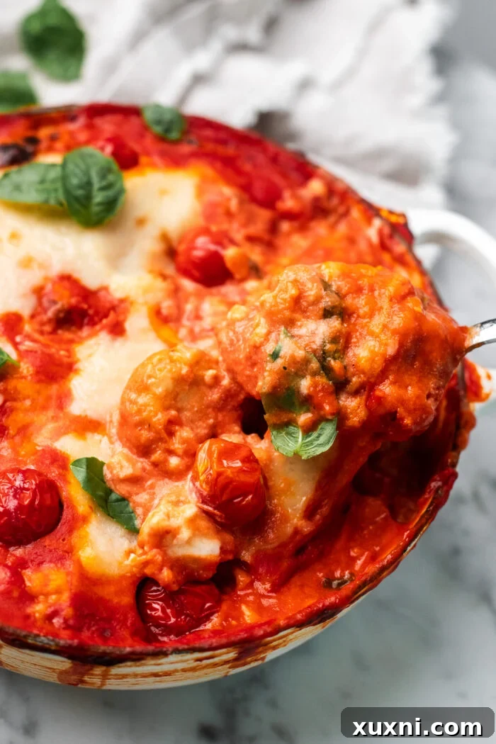 A close-up of a slotted spoon scooping cooked gnocchi out of a pot, ready to be added to the sauce.