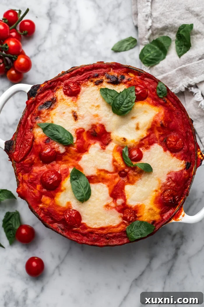 A freshly baked dish of Gnocchi alla Sorrentina, garnished with vibrant fresh basil leaves, hot and ready to serve.