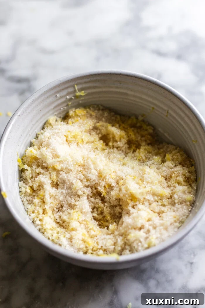 Lemon zest being rubbed into sugar to create aromatic lemon sugar.