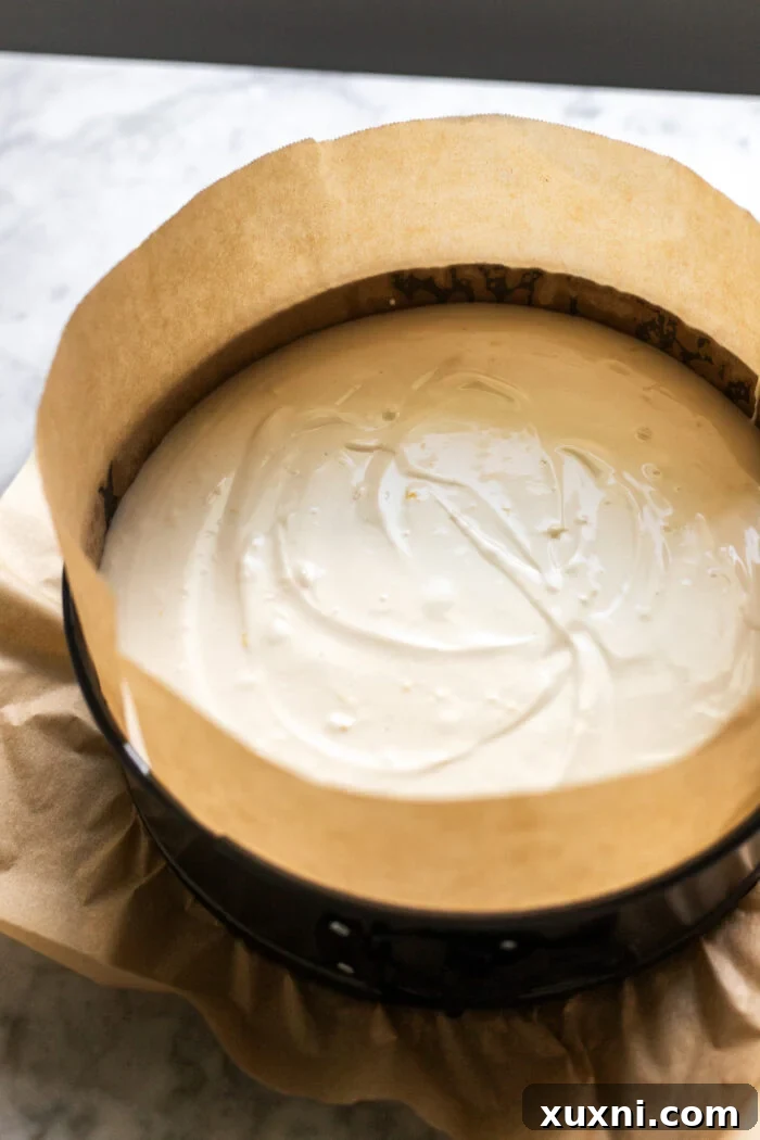 Vegan lemon cheesecake filling poured into the crust, ready for baking.
