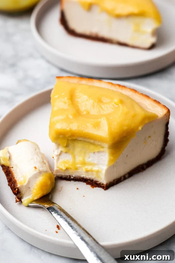 A slice of vegan lemon cheesecake with a bite taken out, showing its luscious interior.