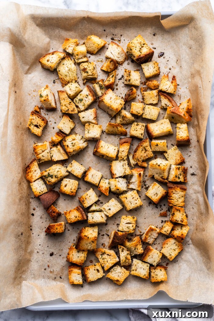 Super Simple Vegan Caesar with Zesty Lemon Tofu 4 Freshly baked homemade croutons cooling on parchment paper, golden and inviting.