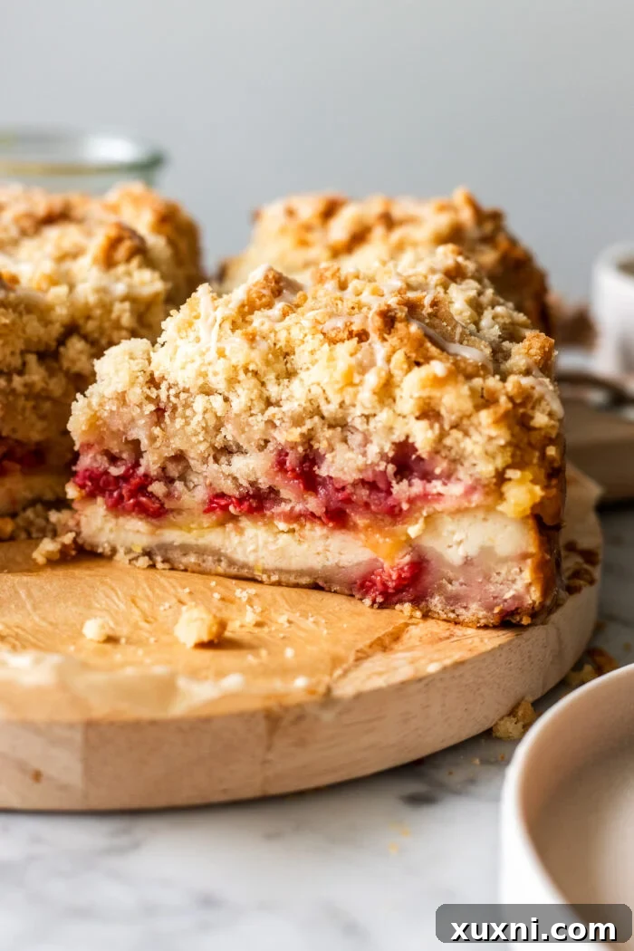 Irresistibly Soft Vegan Lemon Raspberry Coffee Cake with a Zesty Vegan Cream Cheese Swirl 3 Several slices of vegan lemon raspberry coffee cake neatly arranged on a white serving plate, showcasing the layers of cake, cream cheese, and lemon curd.