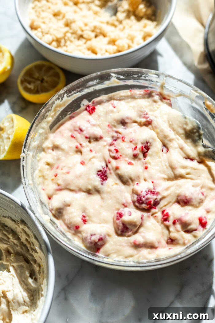 Irresistibly Soft Vegan Lemon Raspberry Coffee Cake with a Zesty Vegan Cream Cheese Swirl 5 Close-up of the vibrant raspberry coffee cake batter in a bowl, showing the dispersed raspberries.