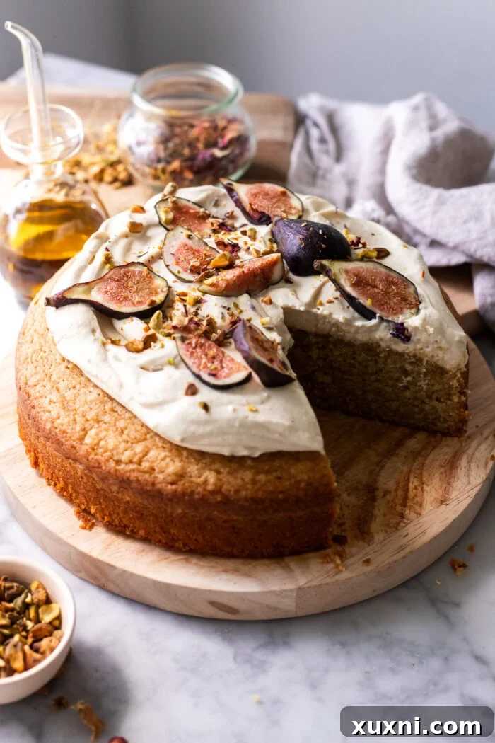 A perfectly sliced vegan olive oil cake with creamy mascarpone topping on a rustic wooden board, showcasing its tender crumb.