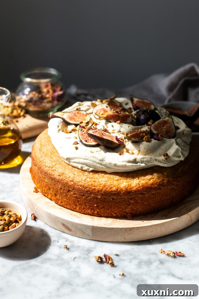 A fully assembled vegan olive oil cake generously topped with dairy-free mascarpone cream and fresh fruit.