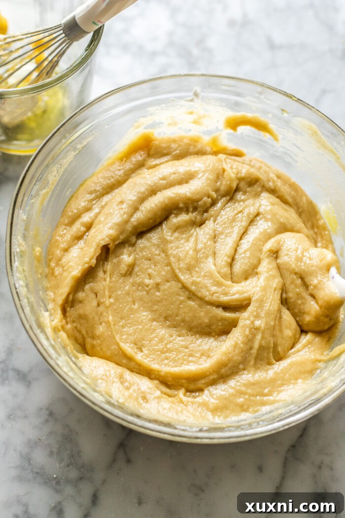 Smooth, pale yellow vegan olive oil cake batter in a mixing bowl, ready for baking.