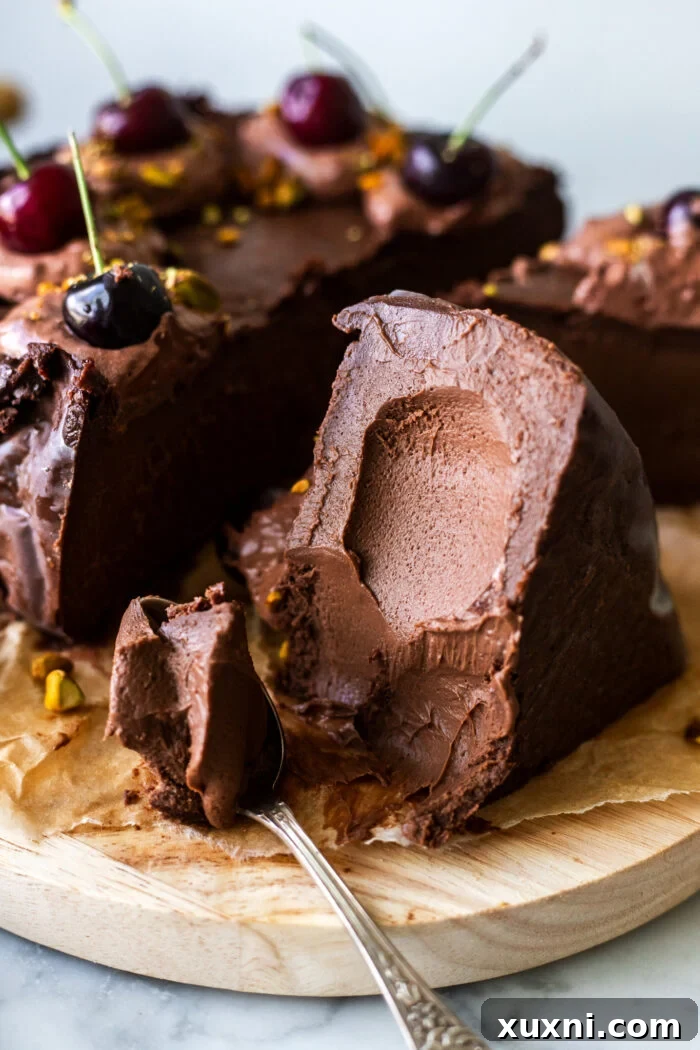 Luxuriously Creamy Vegan Chocolate Basque Cheesecake 4 A close-up shot of a thick slice of creamy chocolate Basque cheesecake on a white plate.
