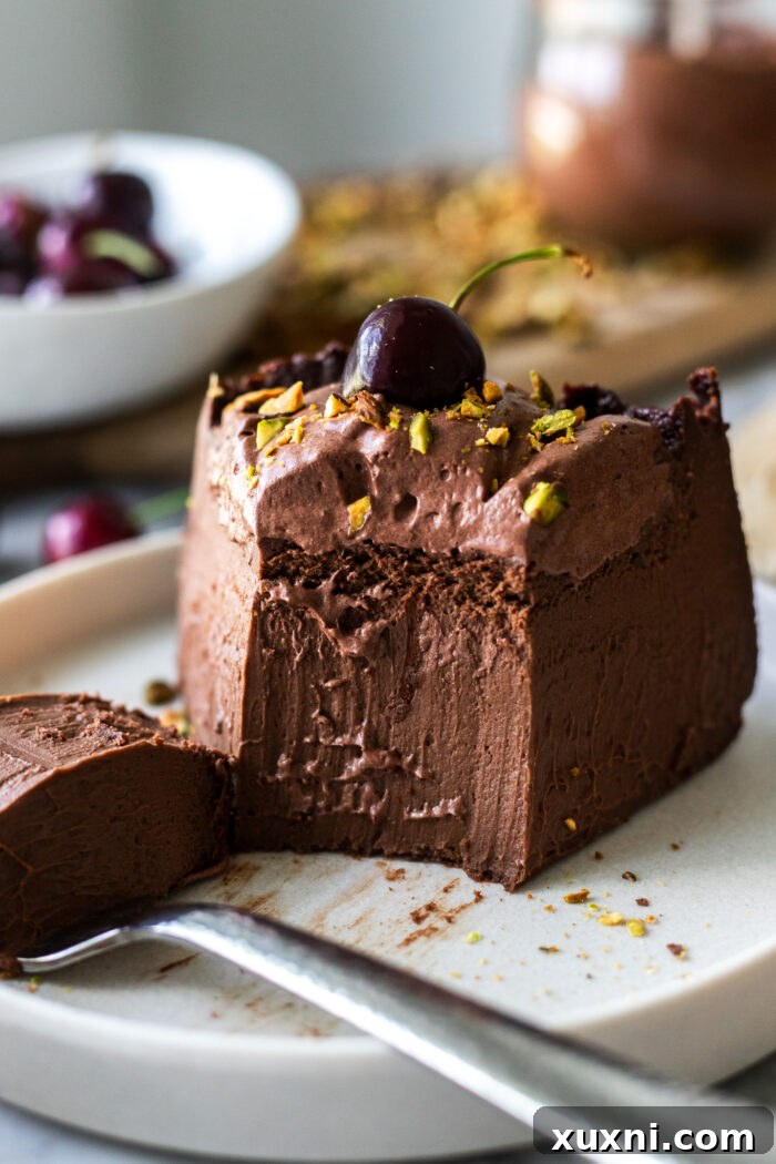 Luxuriously Creamy Vegan Chocolate Basque Cheesecake 9 A vegan chocolate Basque cheesecake with a slice removed, revealing its soft, creamy interior.