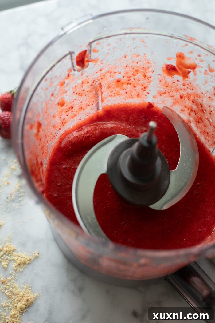 Homemade strawberry puree simmering on the stovetop, reducing in volume