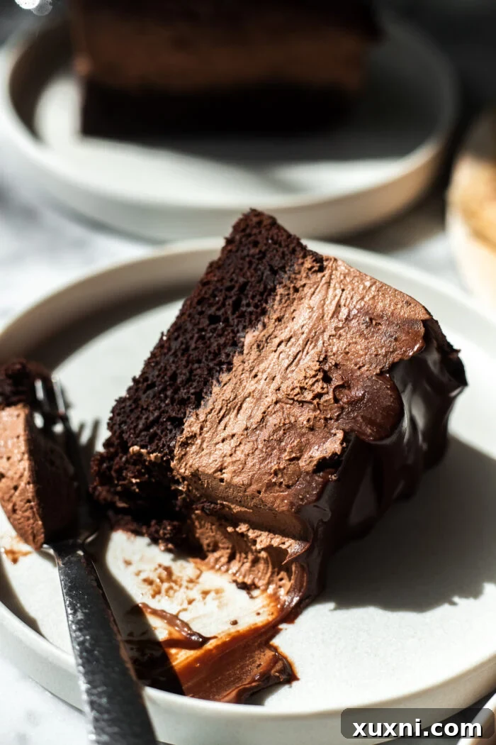 August's Banana Bliss: The Baking Crew's Latest Creation 2 A beautifully presented slice of vegan chocolate mousse cake, with a bite taken out, resting on a white plate next to a fork.