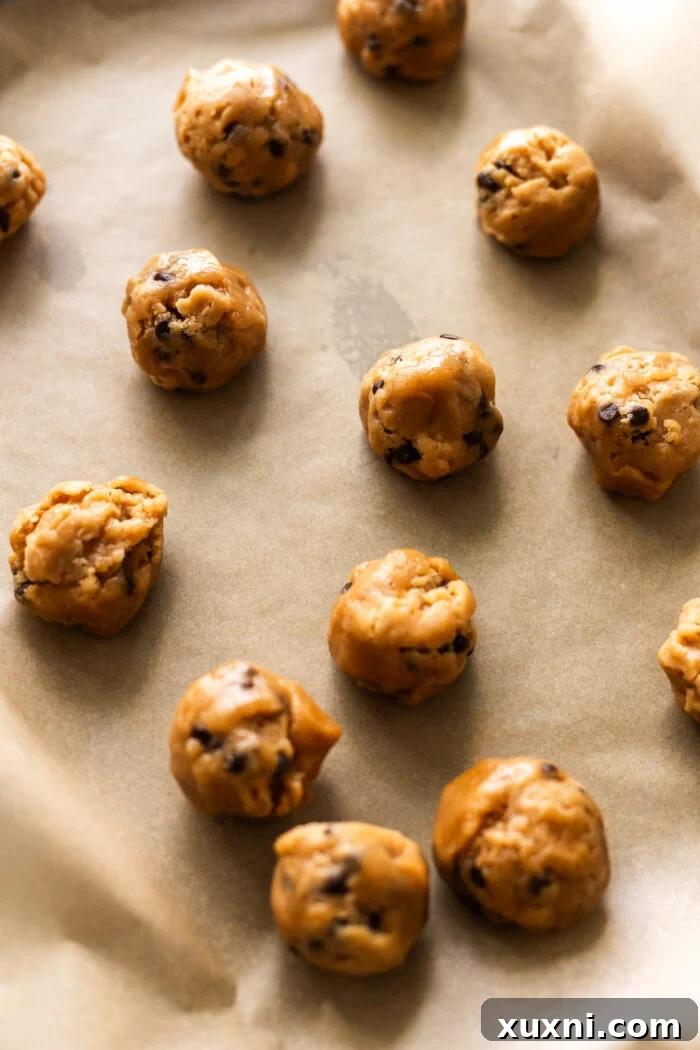 scooped peanut butter cookie dough balls on parchment paper