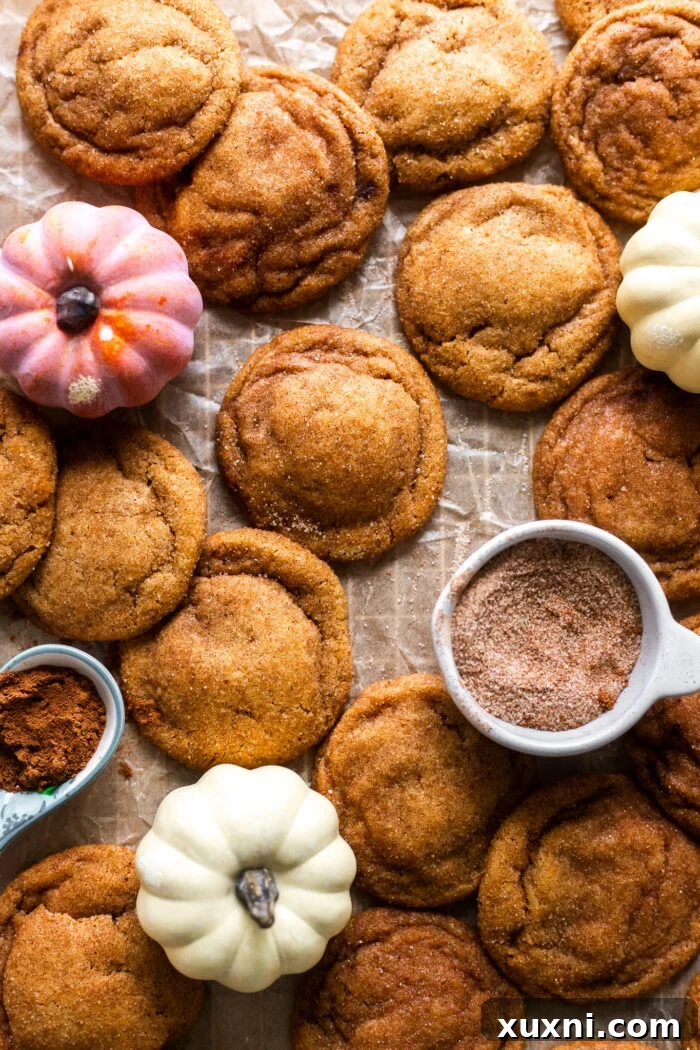 Vegan Brown Butter Pumpkin Snickerdoodle Delight 2 Delicious vegan pumpkin snickerdoodle cookies cooling on parchment paper after baking