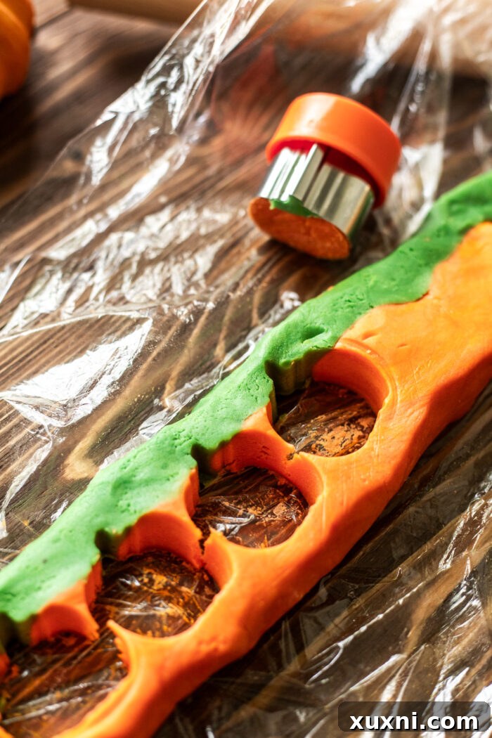 cutting out the pumpkin sugar cookies