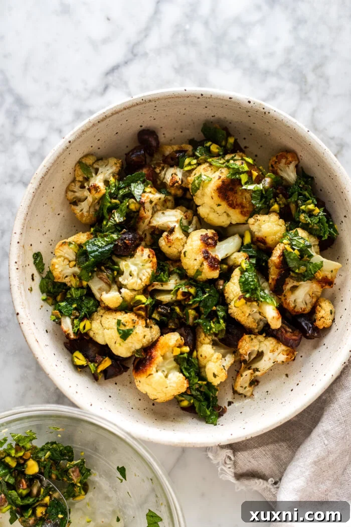 roasted cauliflower in a bowl with vibrant pistachio mint gremolata