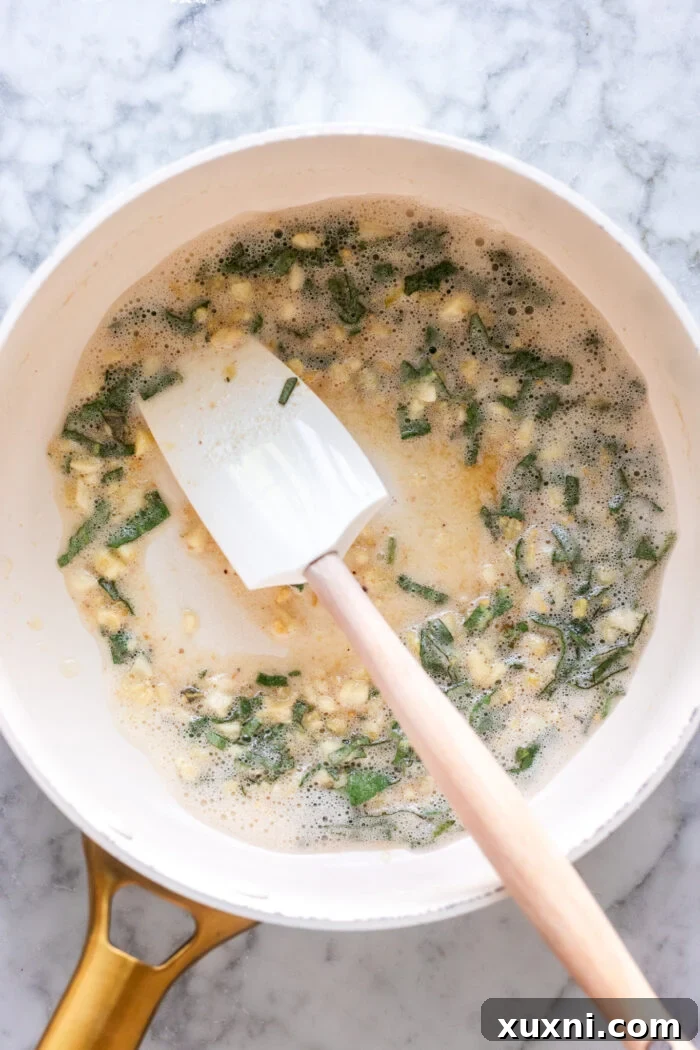Fresh sage leaves being sautéed in the garlic brown butter sauce, becoming fragrant.
