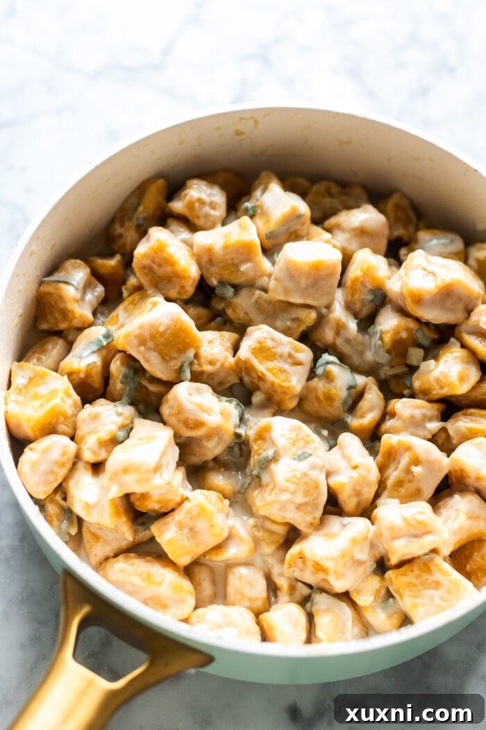 Cooked pumpkin gnocchi tossed in the sage brown butter sauce in a sauté pan.