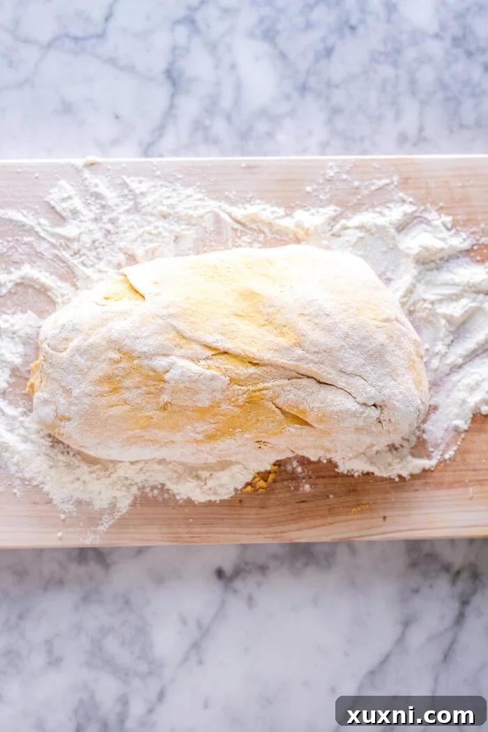 Pumpkin gnocchi dough rolled into a long, even rope, ready for slicing.