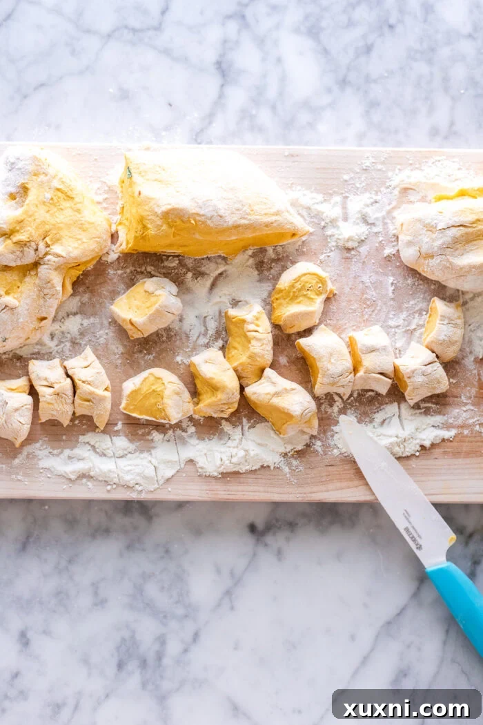 Freshly sliced pumpkin gnocchi, showcasing their readiness for cooking and the perfect shape.