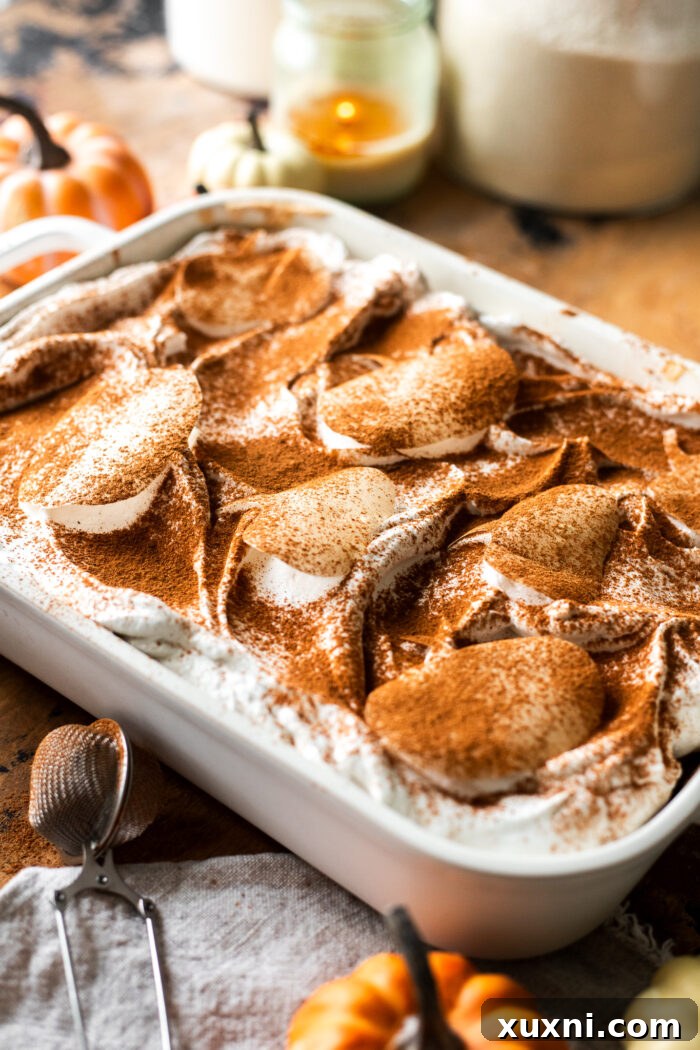 Parchment paper pumpkin stencil carefully placed on top of a smooth layer of vegan whipped cream, ready for dusting.