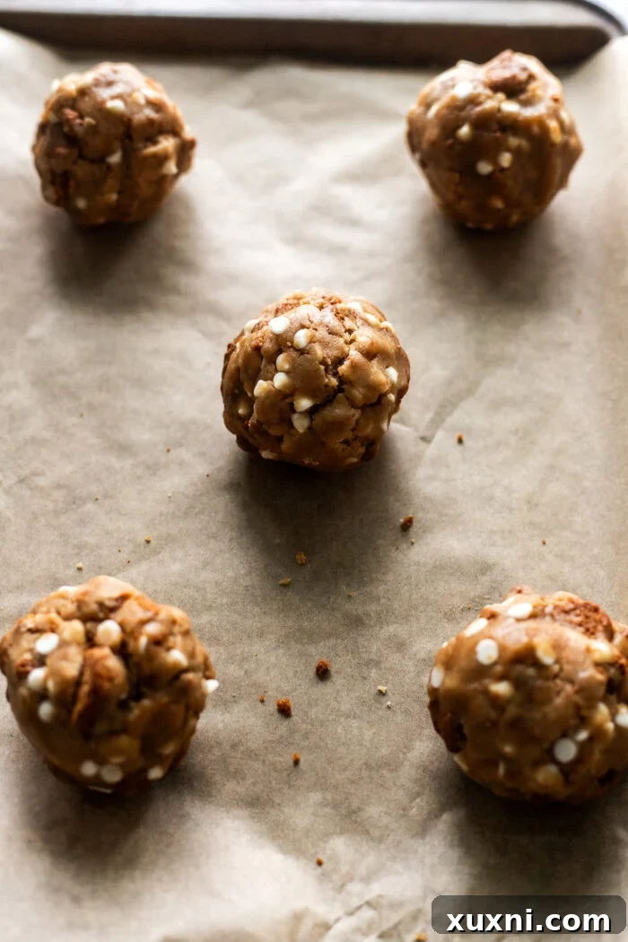 Unbaked vegan cookie butter cookies spaced on parchment paper on a baking sheet.