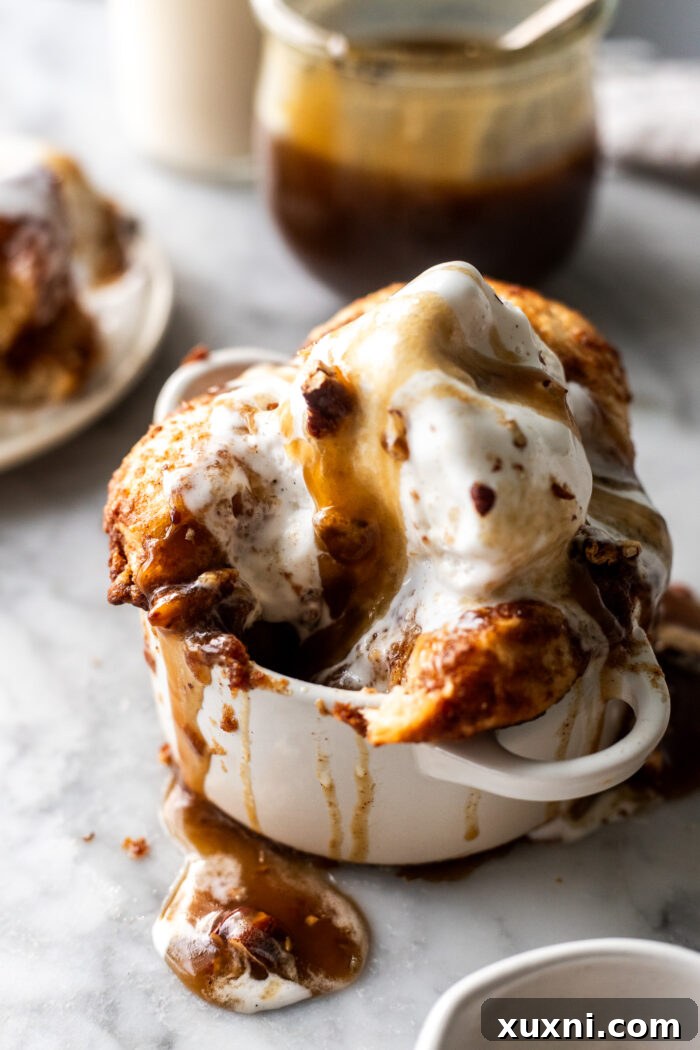 Individual sticky toffee monkey bread, drizzled with toffee sauce and topped with a scoop of vegan ice cream, ready to be enjoyed
