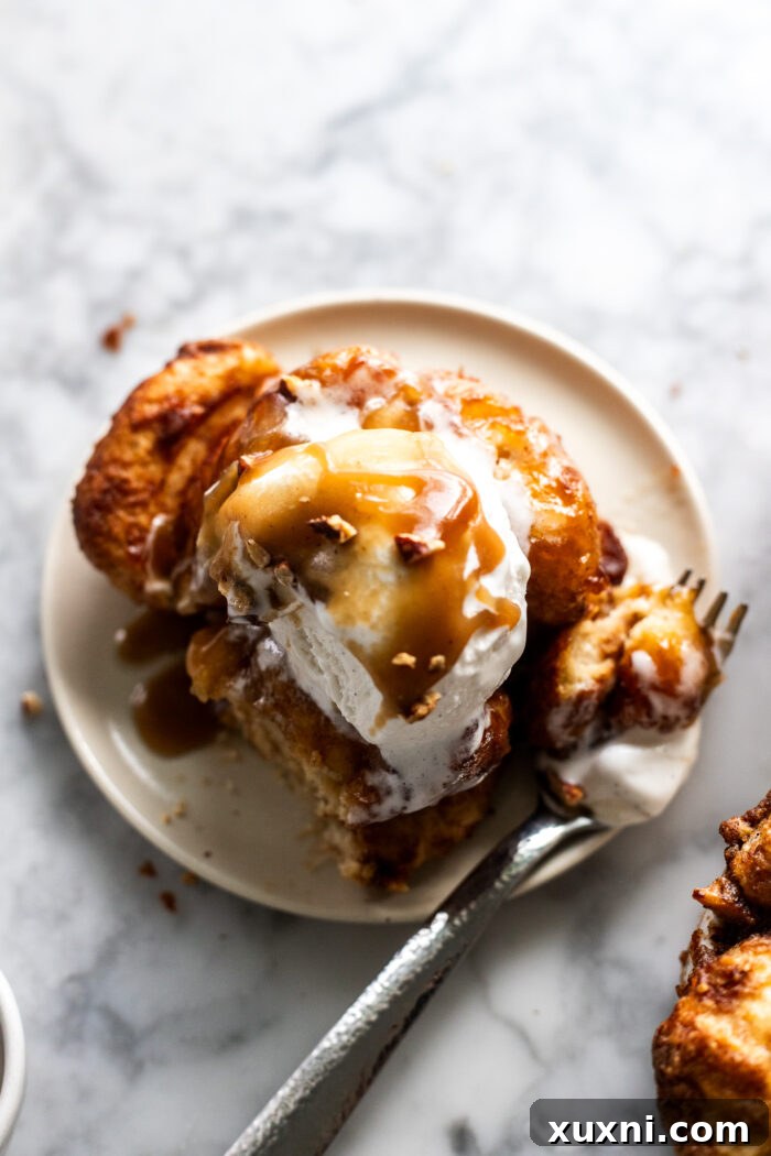 A close-up of a partially eaten sticky toffee monkey bread, revealing its tender, pull-apart texture and rich, sweet layers