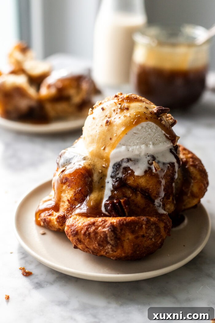 A small batch sticky toffee monkey bread, removed from its ramekin, showcasing its golden-brown, gooey exterior and rich toffee sauce