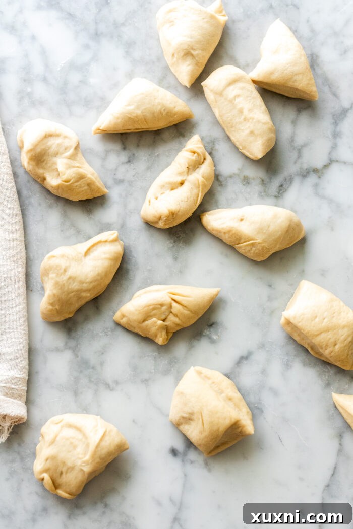 Shaping small dough balls for monkey bread, preparing them for coating