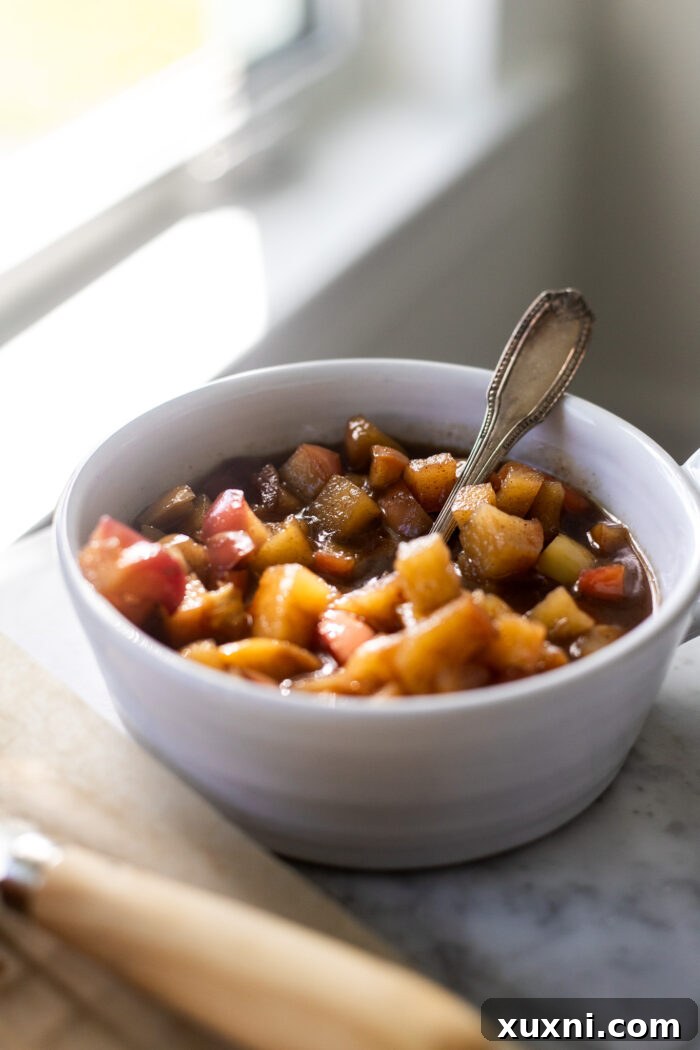 A bowl of tender, gooey cinnamon apples, ready to be used as filling for brioche buns.