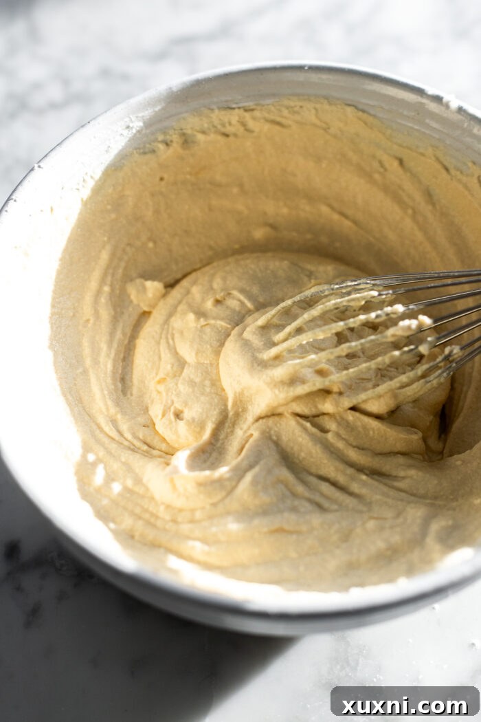 A bowl of creamy homemade vegan cream cheese filling, prepared for the apple cheesecake brioche buns.