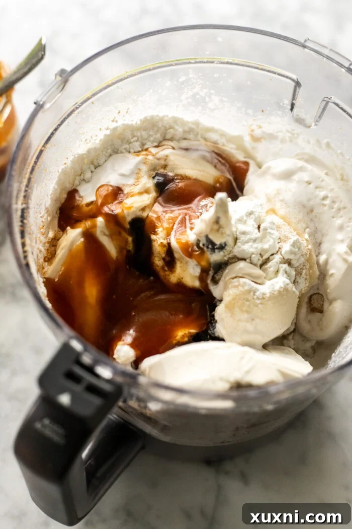 Ingredients being blended in a food processor to make the creamy cheesecake batter