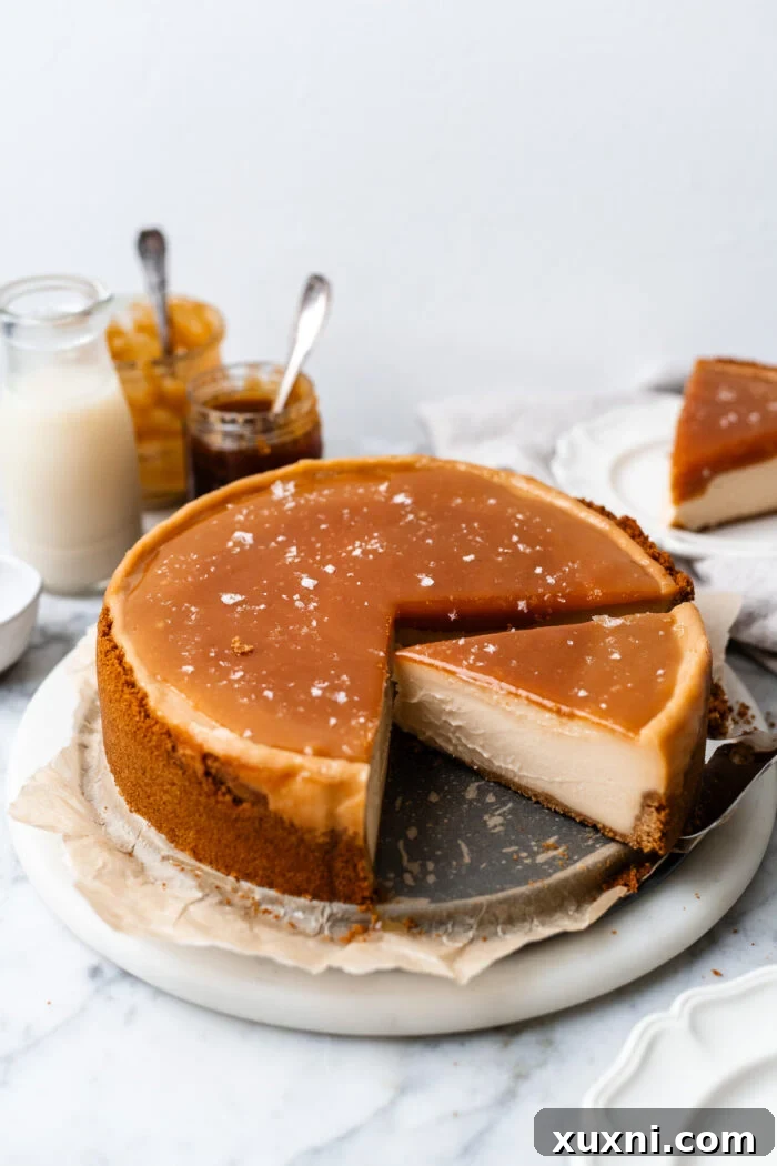 A beautifully sliced vegan caramel cheesecake, topped with glistening caramel sauce