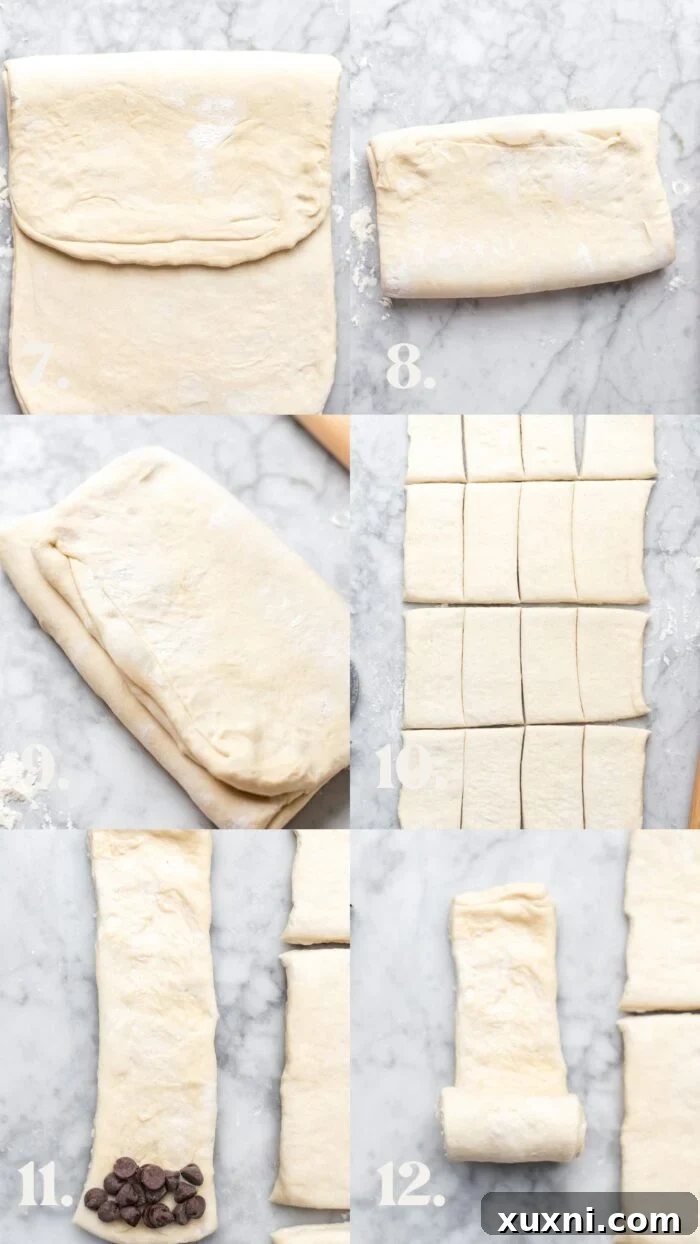 Hands demonstrating how to roll vegan pain au chocolat with a stick of chocolate inside the dough.
