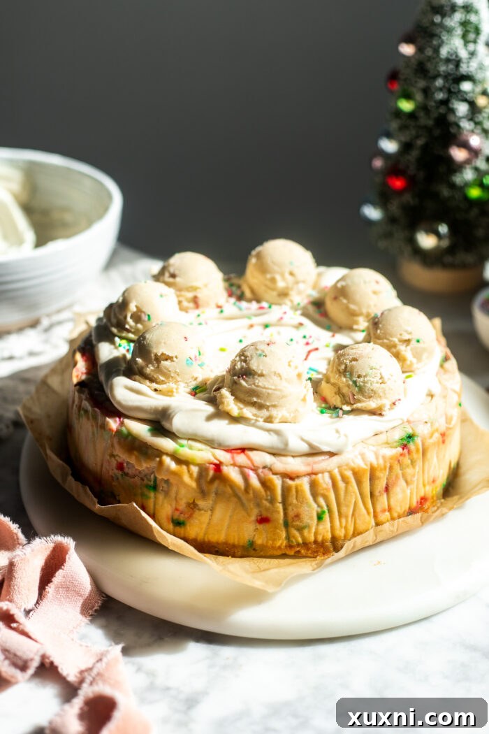 Decorated vegan sugar cookie dough cheesecake with cream cheese frosting and extra cookie dough bites.