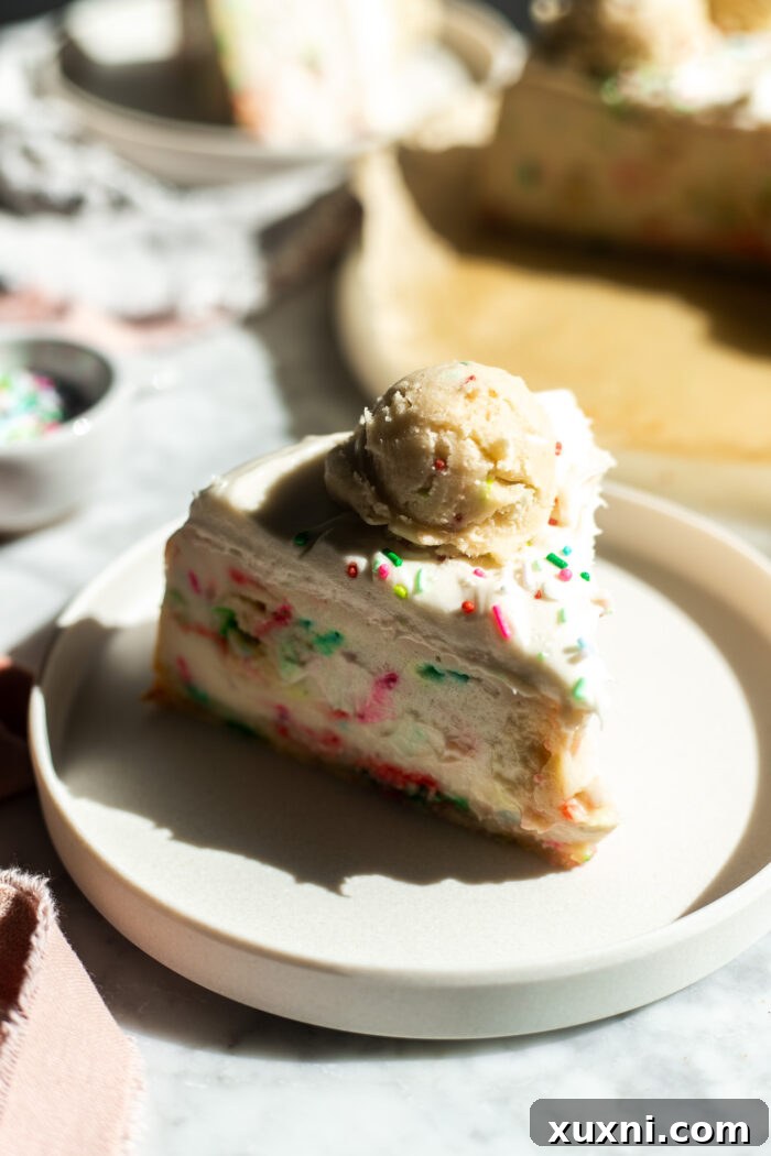 Vibrant sprinkles visible in a cross-section of the baked vegan sugar cookie dough cheesecake.