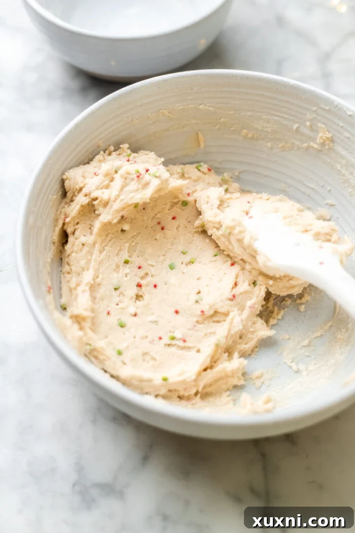 Preparing the vegan shortbread crust for the sugar cookie dough cheesecake in a bowl.